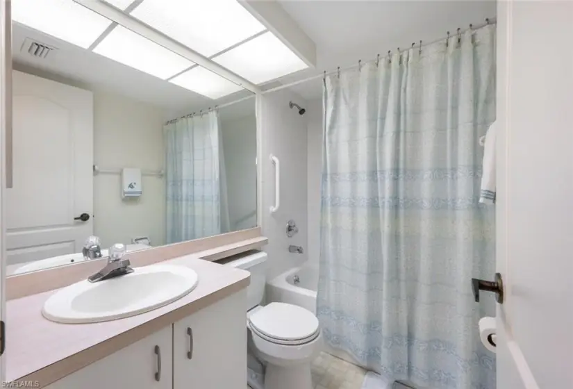 Full bathroom featuring tile flooring, shower / tub combo with curtain, vanity, and toilet