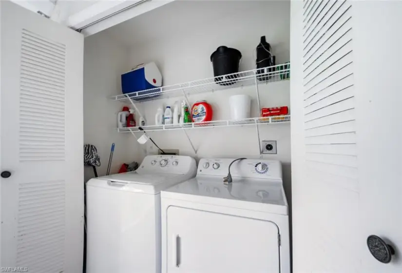 Clothes washing area featuring electric dryer hookup and washer and clothes dryer