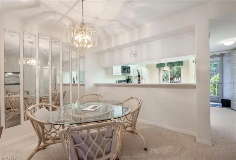 Dining space with carpet floors and an inviting chandelier