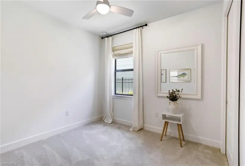 Carpeted empty room featuring ceiling fan