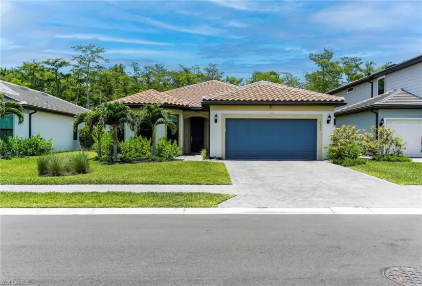 Mediterranean / spanish house featuring a garage and a front lawn