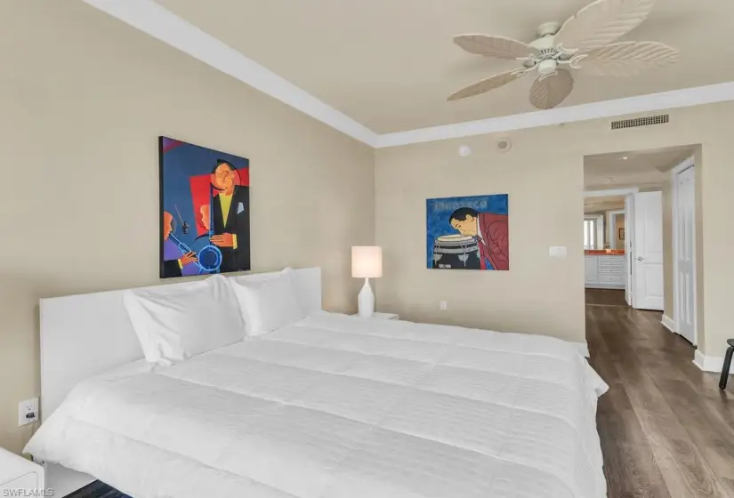 Bedroom with ceiling fan, ornamental molding, and wood-type flooring