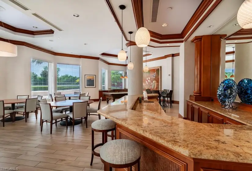 Kitchen featuring decorative light fixtures, light stone countertops, and a healthy amount of sunlight