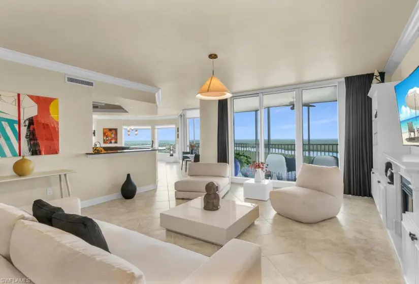 Tiled living room featuring a water view and ornamental molding